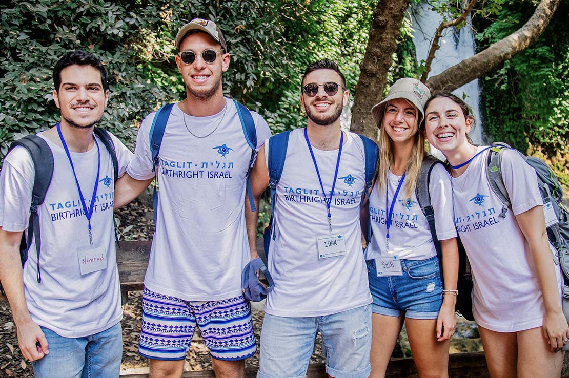 A Birthright Israel group on top of Masada under a large Israeli flag