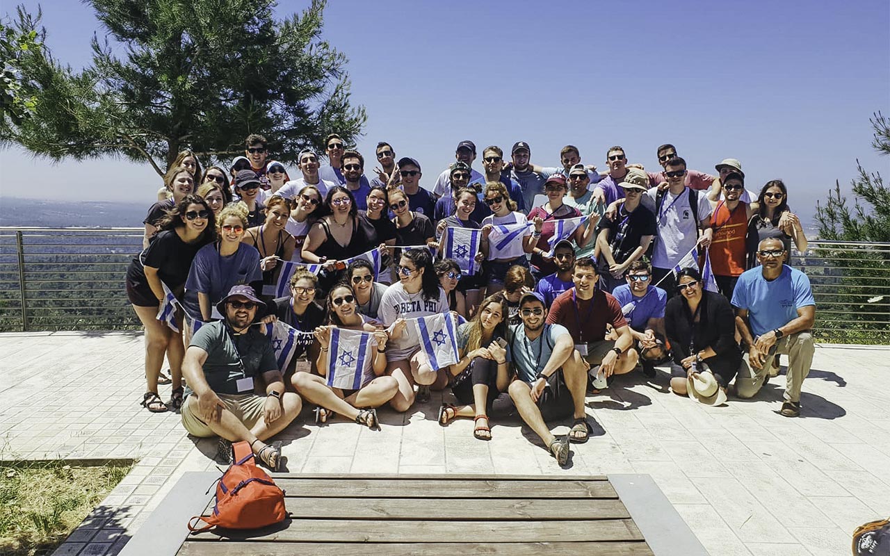 Cooper Myers with his 2019 Birthright Israel group holding Israeli flags