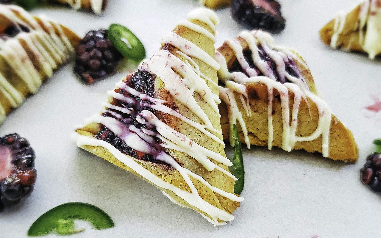 Close-up shot of blackberry mojito hamantaschen with white chocolate drizzles