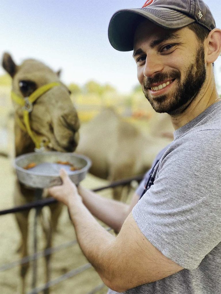 Ethan Bettinger feeding a camel in the Negev on his 2021 Birthright Israel trip
