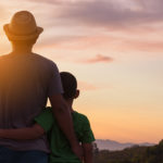 A father and son looking at the sunset