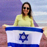 Samantha Rubenstein holding an Israeli flag on her Birthright Israel trip